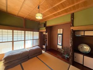 a bedroom with a bed and a large window at ゐらくさ in Yaizu