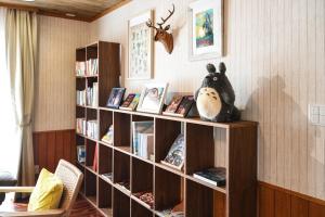 a book shelf with books and a stuffed animal on it at リトリート禅の宿 in Owariasahi