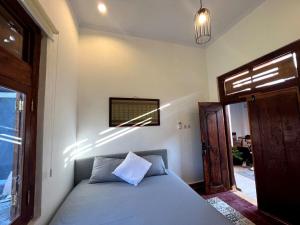 a bedroom with a bed and a window at Sabi House Danu, Family Home near Prawirotaman in Timuran
