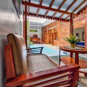 a living room with a couch and a table and a pool at Sabi House Danu, Family Home near Prawirotaman in Timuran