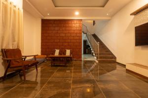 a hallway with a staircase with chairs and a table at Babji villa in Kolhapur Airport