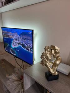 a statue sitting on a table in front of a television at Mandi's Apartment in Ksamil