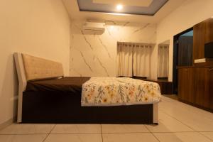 a bedroom with a bed with a comforter on it at Babji villa in Kolhapur Airport