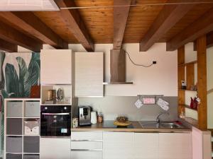 a kitchen with white cabinets and a sink at Il Giardino di Bronto-lo in Crosare +4 photos