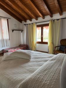 a bedroom with a large white bed and a window at Il Giardino di Bronto-lo in Crosare