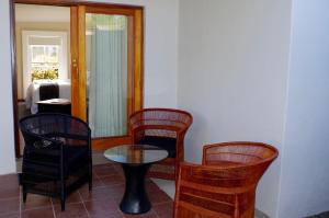 グラスコップにあるGraskop Harrie's Cottageの椅子、テーブル、鏡付きの部屋