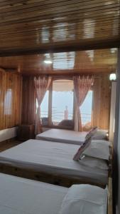 three beds in a room with a window at Dafey Homestay in Darjeeling +19 photos