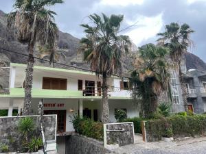 a building with palm trees in front of it at Divin'Art in Tarrafal da Vila de Ribeira Grande +14 photos