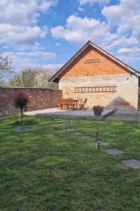 a brick building with a picnic table in the grass at Miljana in Vukovar