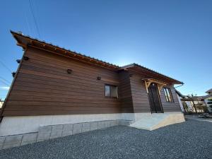 a house with wooden siding on the side of it at ゐらくさ in Yaizu