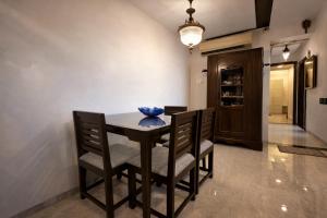 a dining room table with chairs and a blue napkin on it at Pet Friendly Spacious 3 BHK Penthouse in Mumbai