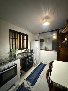 a kitchen with a sink and a stove top oven at Chalé com vista na vila centro histórico in Ilhabela