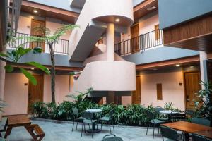 a lobby with tables and chairs in a building at Liberta Malioboro North in Yogyakarta