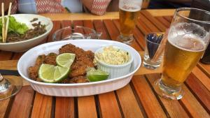 a white bowl of food on a table with drinks at Chalé com vista na vila centro histórico in Ilhabela