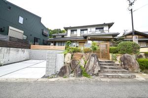a house with some rocks in front of a house at リトリート禅の宿 in Owariasahi
