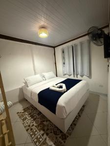 a bedroom with a large bed with a blue blanket at Chalé com vista na vila centro histórico in Ilhabela