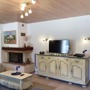 a living room with a tv on top of a cabinet at Villa Rose in Seignosse