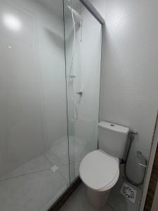 a bathroom with a toilet and a glass shower at Apartamento Novo Infinity in Vila Velha