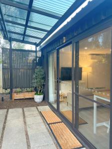 ein Wintergarten mit Glastüren und ein Wohnzimmer in der Unterkunft Rustic PepperTree Views in Rockingham