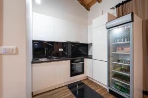 a kitchen with white cabinets and a refrigerator at VILA K3 Podgorica in Podgorica