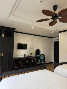 a bedroom with a bed and a ceiling fan at Indocharm Villa Cat Ba in Cat Ba