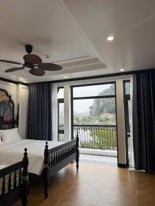 a bedroom with a bed and a large window at Indocharm Villa Cat Ba in Cat Ba