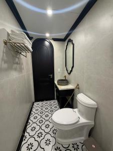 a bathroom with a toilet and a black door at Indocharm Villa Cat Ba in Cat Ba +19 photos