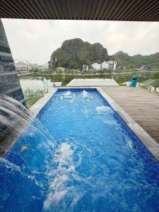 a swimming pool with a water fountain at Indocharm Villa Cat Ba in Cat Ba