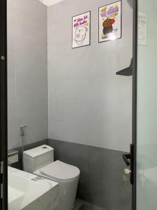a white bathroom with a toilet and a sink at DeHa Homestay in Hue