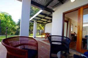 格拉斯科普Graskop Harrie's Cottage的门廊配有2把椅子和桌子