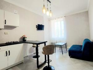 a kitchen and living room with a table and a blue couch at Центр,дитяче містечко Казка in Mykolaiv
