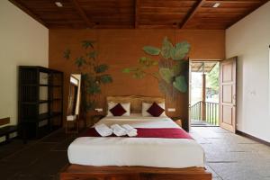 a bedroom with a bed with a tree mural on the wall at Aalterra Resort by The Almanac in Wayanad +244 photos
