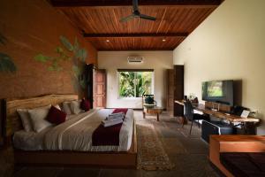 a bedroom with a bed and a desk and a computer at Aalterra Resort by The Almanac in Wayanad