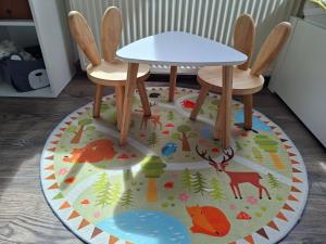 a table and two chairs on top of a rug at Apartmán 29 LANOVKA in Jáchymov