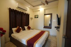 a bedroom with a bed and a television in it at Hotel Seva in Nagpur