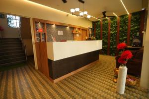 a lobby with a counter and flowers in a room at Hotel Seva in Nagpur
