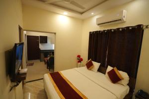 a hotel room with a bed and a television at Hotel Seva in Nagpur