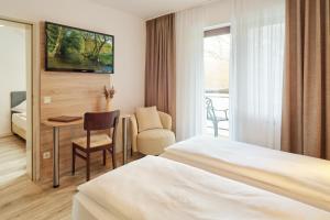 a hotel room with a bed and a table and a chair at Hotel und Weingut Karlsmühle in Mertesdorf