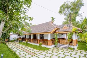 a villa with a garden and a house at Nature Land in Alleppey