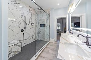 a bathroom with two sinks and a shower with marble walls at The White Inn in Fredonia +105 photos