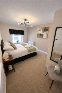 a bedroom with a large bed and a window at Charming 3 Bedroom High St Apartment in Much Wenlock