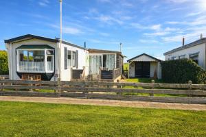 a house with a wooden fence and grass at Moonlight Nature Holiday Home in Westergeest