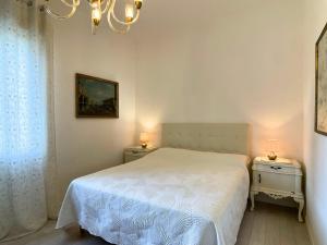 a bedroom with a white bed and two night stands at Lizard Residence in Lido di Jesolo