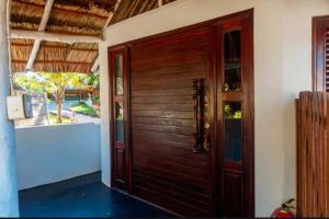 a wooden door of a house with a window at Boa Gente Lodge in Vilanculos