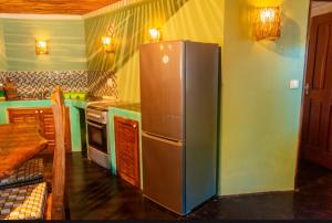 a kitchen with a stainless steel refrigerator and a table at Boa Gente Lodge in Vilanculos