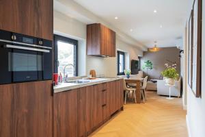 a kitchen with wooden cabinets and a dining room at Boetiek ManjaFiek in Zandvoort