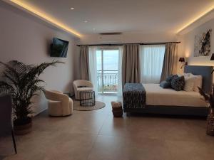 a bedroom with a bed and a chair and a window at Villa Nina Adult only in Skiathos