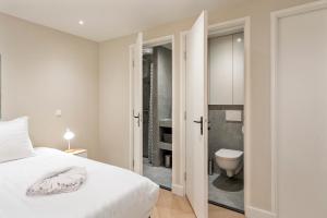 a bedroom with a white bed and a bathroom at Boetiek ManjaFiek in Zandvoort +26 photos
