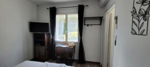 a bedroom with a window and a bed and a television at Chambre la Belle Étape in Martinet