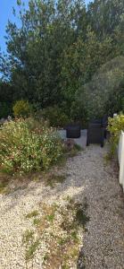 two black chairs sitting in a garden with flowers at Chambre la Belle Étape in Martinet